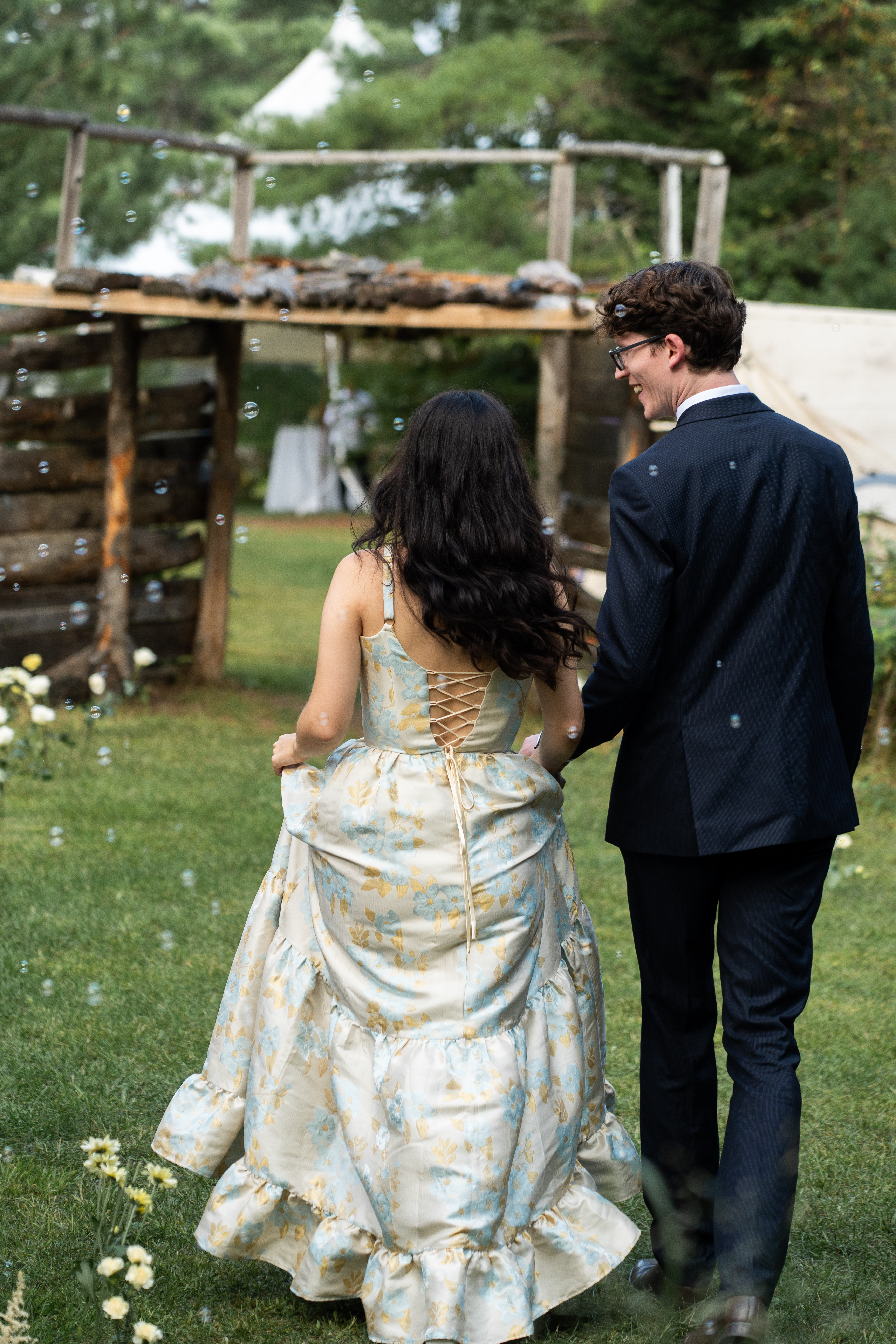 Two newly weds walking through bubbles